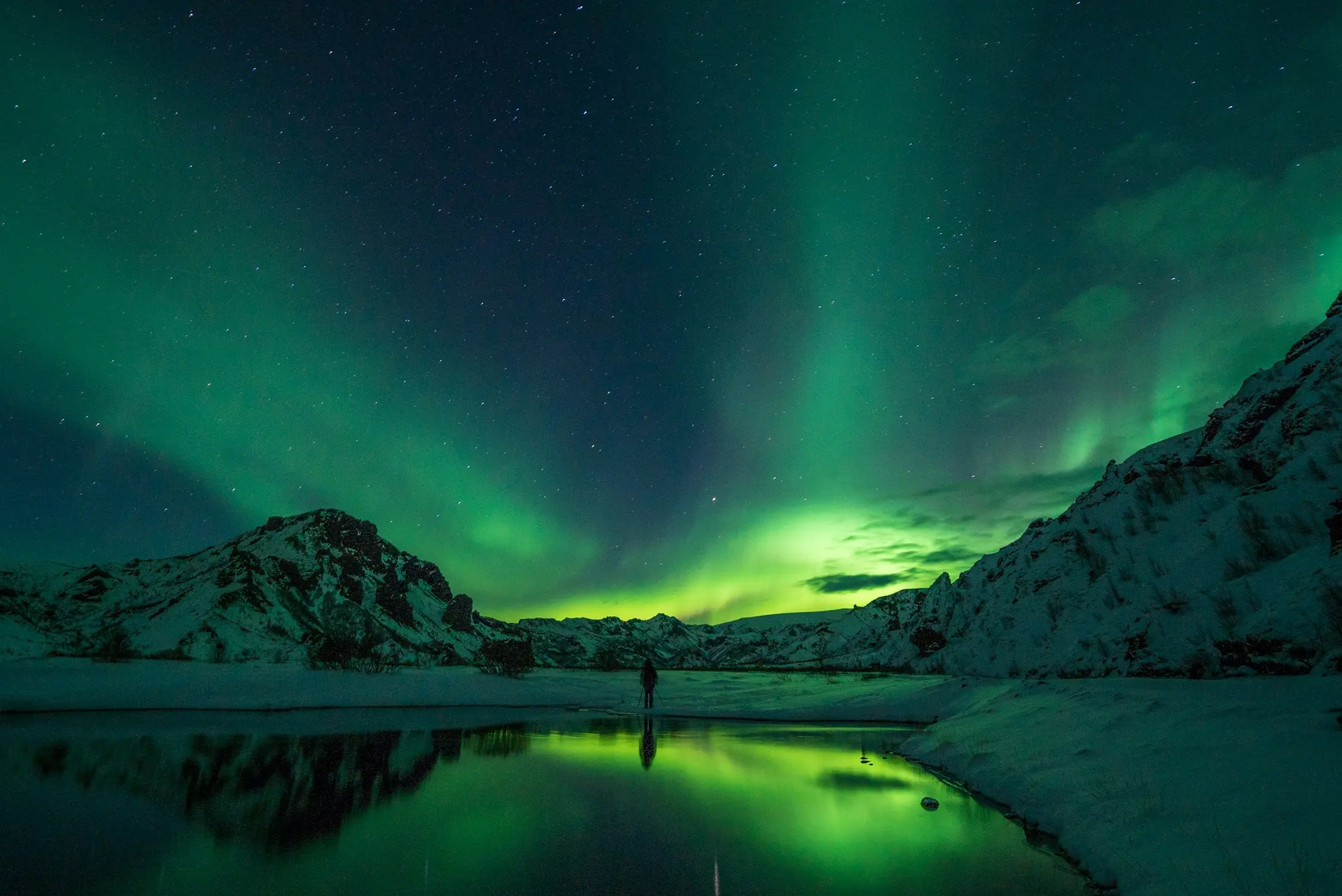Aurora boreal verde sobre montañas de Islandia en plena noche